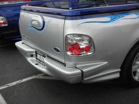 1992 Ford Crown Victoria - This pickup truck features custom blue flame graphics on its silver body and a blue tonneau cover.