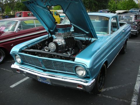 1992 Ford Crown Victoria - A bright blue pickup truck is displayed with its hood open, revealing a powerful supercharged engine and a 'Built Ford Tough' badge.