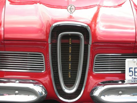1992 Ford Crown Victoria - The chrome grille of a red car spells out "EDSEL" vertically.