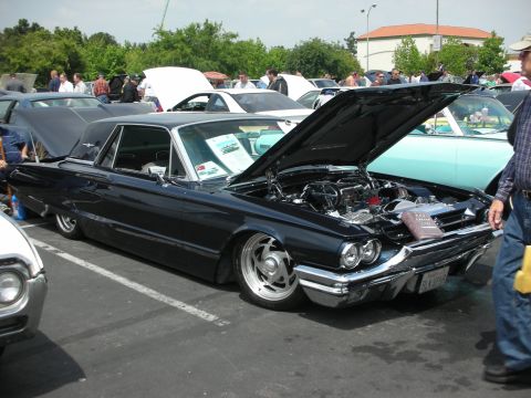 1992 Ford Crown Victoria - Dark blue 1961 Ford Thunderbird at a car show, hood up revealing the engine.