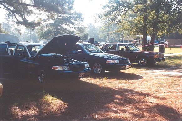 Dark 2002 Ford Crown Victoria with hood open, parked outdoors