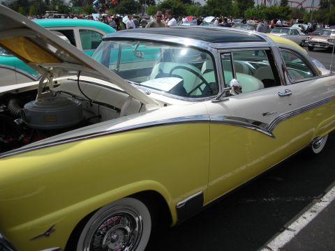 1992 Ford Crown Victoria - A classic two-tone yellow and white Ford Fairlane is displayed with its hood open at an outdoor car show.