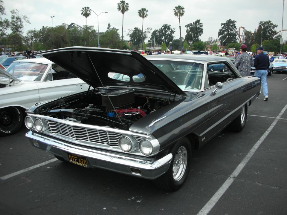 1962 Ford Galaxie with hood open, showing engine. Another car is parked to its left