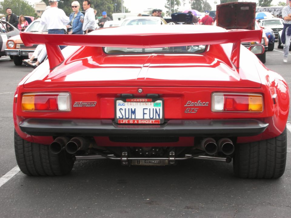 Red sports car with a large rear wing and quad exhaust pipes