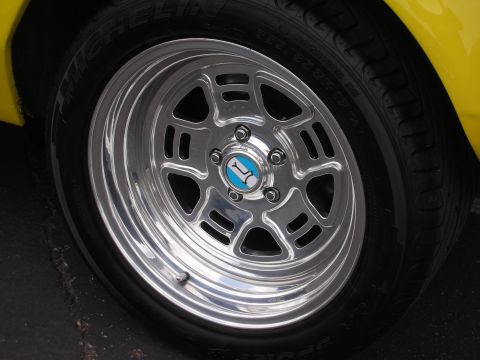 1992 Ford Crown Victoria - Close-up of a shiny chrome wheel with a distinctive blue and white center cap.