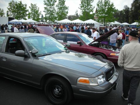 1992 Ford Crown Victoria - A gray 1992 Ford Crown Victoria police car is parked next to another vehicle at a car show.