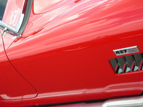 1992 Ford Crown Victoria - Close-up of a red car's side, a '427 COBRA' badge and exhaust pipe.