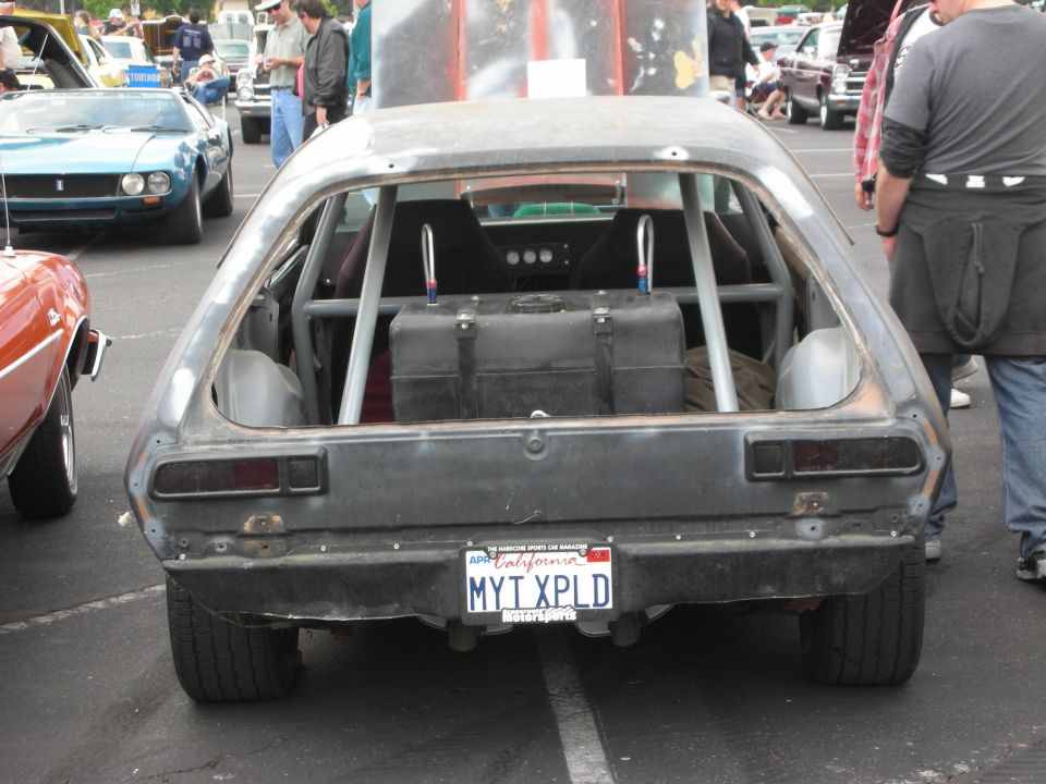 Modified dark gray hatchback with roll cage, racing fuel cell, and California license plate MYT XPLD