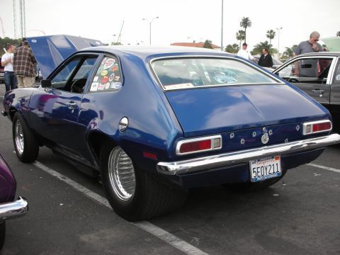 1992 Ford Crown Victoria - A blue coupe with racing slicks and numerous stickers on the rear quarter window is parked at a car show.
