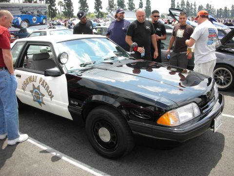 1992 Ford Crown Victoria - This black and white highway patrol car, marked with a 5.0 badge, is on display at a car show.