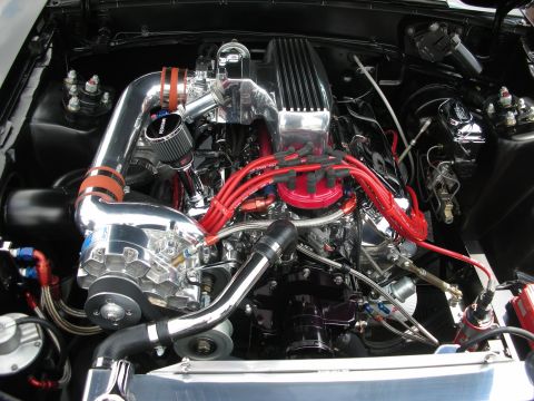 1992 Ford Crown Victoria - The engine bay is filled with chrome and polished metal, a prominent supercharger and bright red spark plug wires.