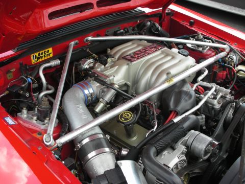 1992 Ford Crown Victoria - Close-up of a red vehicle's engine bay, a "Cobra" intake manifold and an "Auto Meter" sticker.