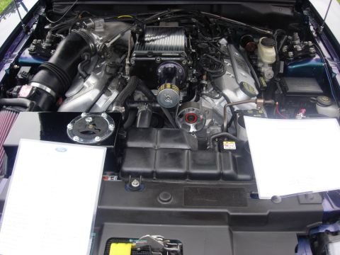 1992 Ford Crown Victoria - The engine bay of a car is shown with a prominent supercharger and intake system.