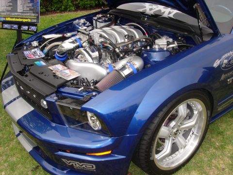 1992 Ford Crown Victoria - Customized blue Ford Mustang with an exposed, turbocharged V8 engine and silver racing stripes.