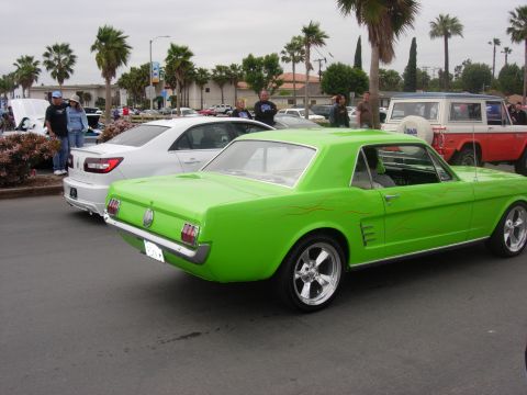 1992 Ford Crown Victoria - A bright green classic car with custom flame decals is parked at an outdoor car show.