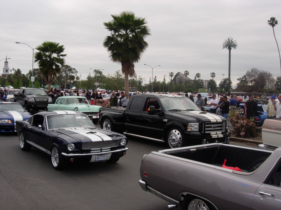 1992 Ford Crown Victoria, dark blue with white racing stripes, front 3/4 view, license plate visible