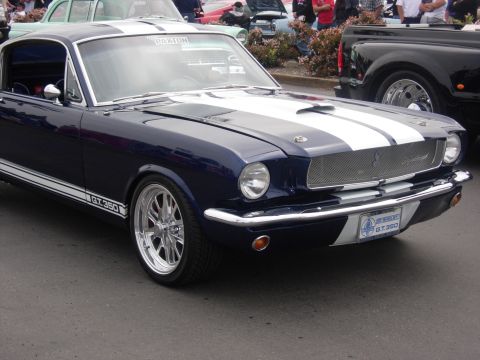 1992 Ford Crown Victoria - A classic dark blue 1966 Ford Mustang GT350 is displayed with white racing stripes and custom chrome wheels.