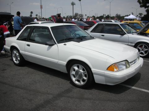 1992 Ford Crown Victoria - A white coupe with a sunroof is parked at an outdoor car show with other vehicles visible.