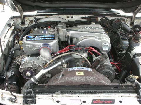 1992 Ford Crown Victoria - Engine bay view of a modified V8 with a prominent supercharger and "CAUTION FAN" warning.