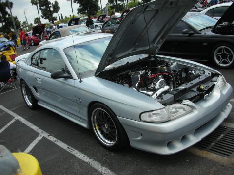 1992 Ford Crown Victoria - Silver Ford Mustang at a car show, hood open to display the engine bay.