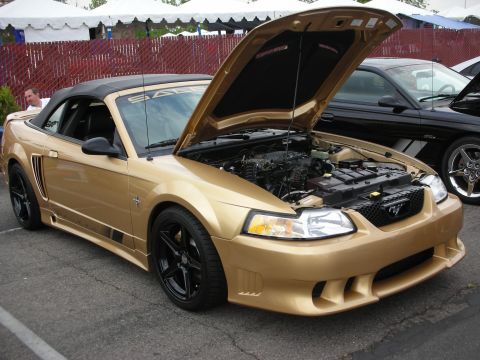 1992 Ford Crown Victoria - Gold convertible Mustang with hood open, parked next to a black Mustang.