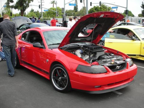 1992 Ford Crown Victoria - A red Ford Mustang is displayed with its hood open, revealing the engine and a prominent air intake scoop.