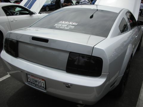 1992 Ford Crown Victoria - A silver Ford Mustang is parked at a car show, with another Mustang visible in the background.