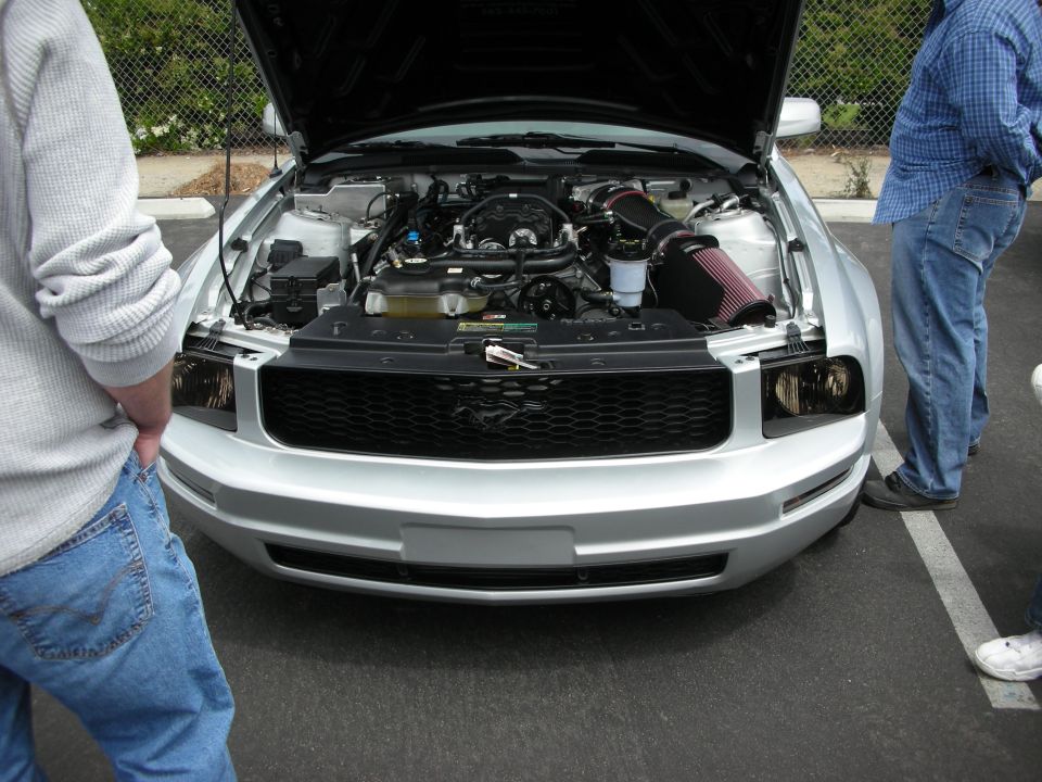 Silver Ford Mustang with hood open showing engine and aftermarket air intake