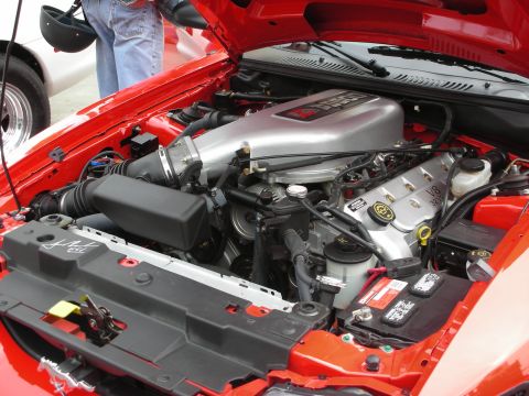 1992 Ford Crown Victoria - The engine bay of a red 1996 Ford Mustang GT, showing its V8 4.6L engine and associated components.