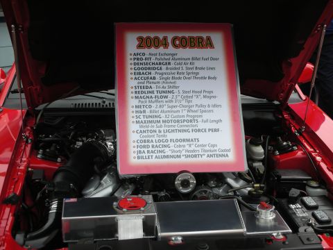1992 Ford Crown Victoria - Engine bay display with a sign listing performance parts for a 2004 Cobra.