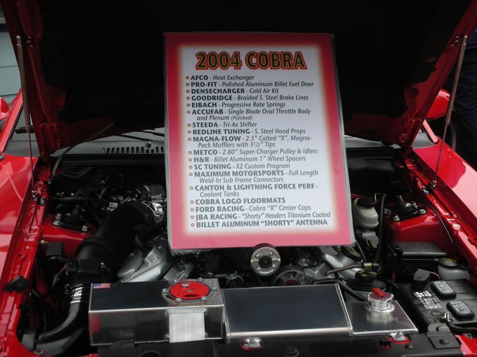 Red engine bay with a sign detailing 2004 Cobra parts list