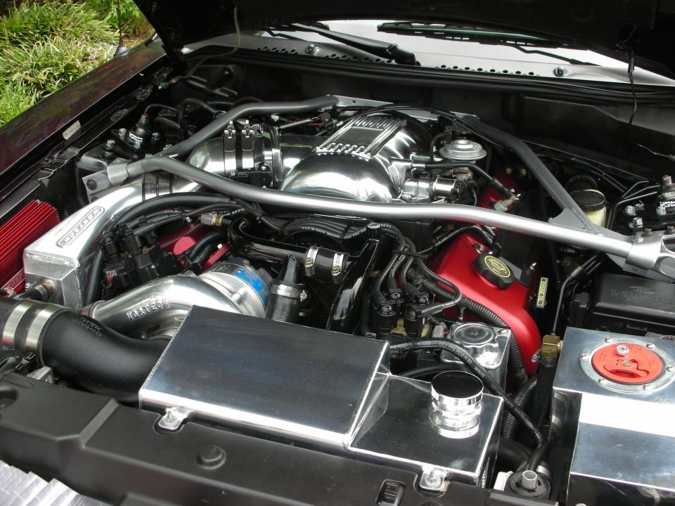 Engine bay with polished intake manifold, turbocharger, and custom fluid reservoirs