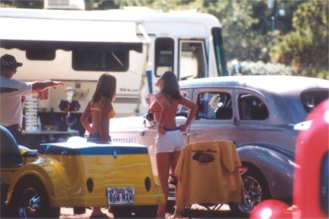 2002 Ford Crown Victoria - A vintage car and trailer are parked near an RV, with two women standing nearby.