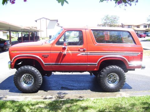 1986 Ford Bronco - This lifted Ford Bronco is shown from the side, its distinctive body style and large tires.