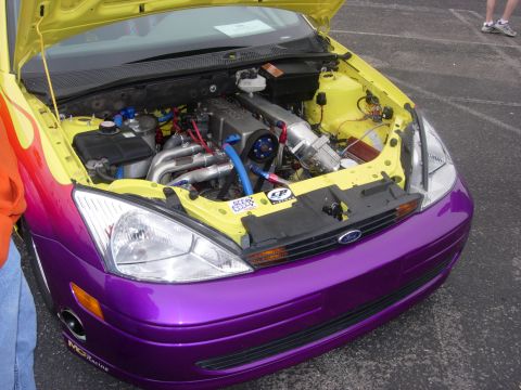 1992 Ford Crown Victoria - A custom-painted Ford Focus displays its modified engine bay and vibrant purple bumper.