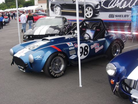 1992 Ford Crown Victoria - A blue Shelby Cobra race car with 'Shelby Cobra Challenge' text and number 98 is parked next to another Cobra.