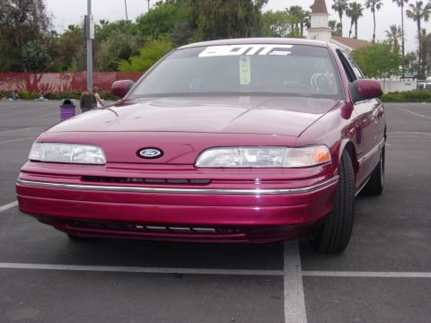 1992 Ford Crown Victoria - Maroon 1992 Ford Crown Victoria with a "BOIIE" banner on the windshield parked in a lot.