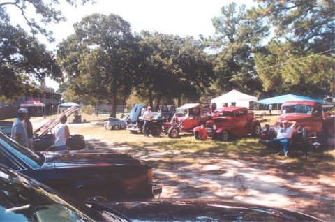 2002 Ford Crown Victoria - A collection of classic vehicles are gathered at an outdoor event under a sunny sky.