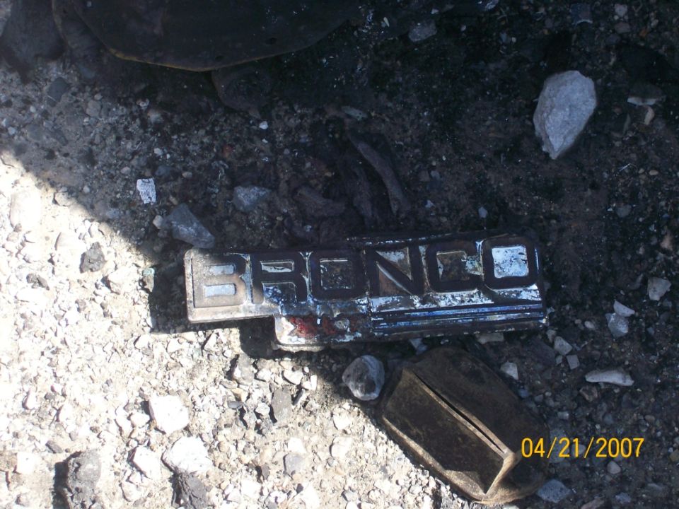 Bronco emblem lying on rocky ground