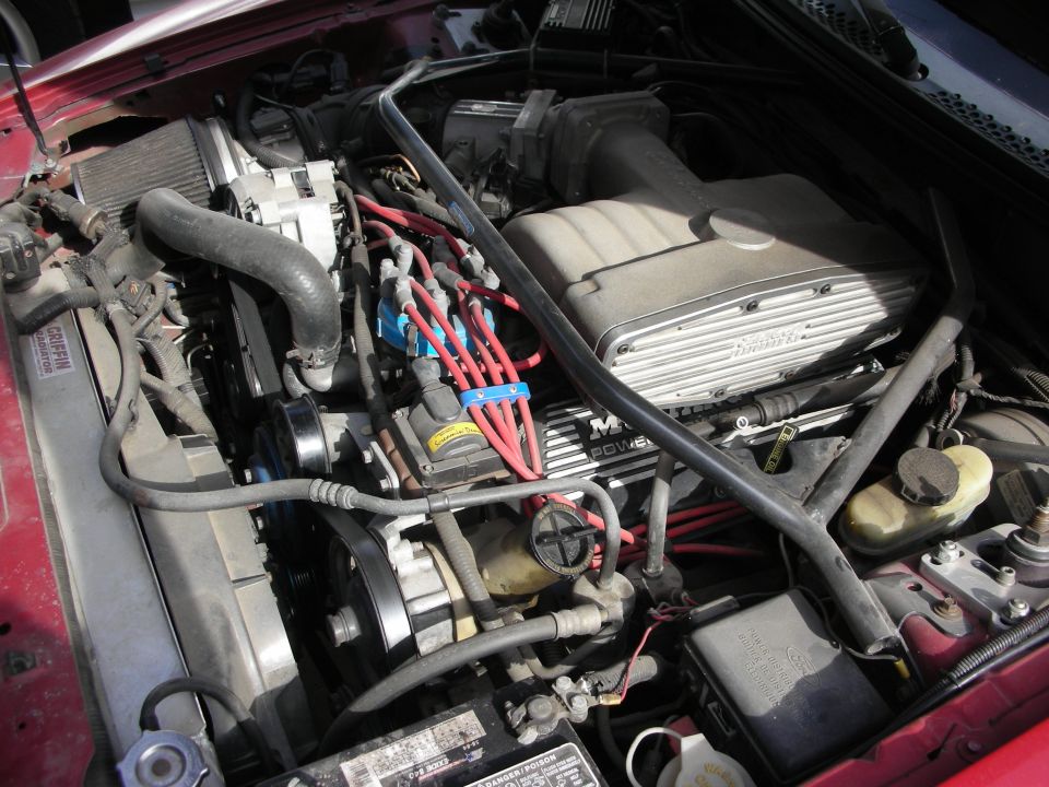 Engine bay with finned intake, red plug wires and underdrive pulleys