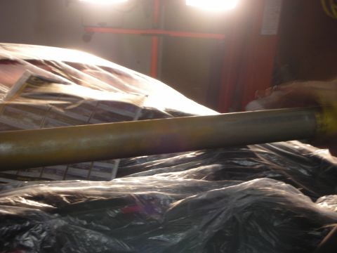 1998 Ford Crown Victoria - car body masked with plastic sheeting and newspaper under bright spray-booth lights, photographed across a curved surface.