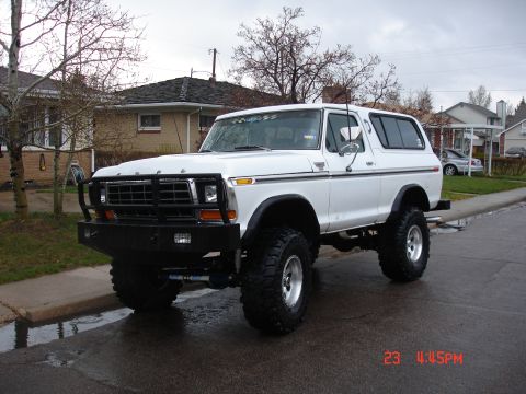 1979 Ford Bronco - This lifted white Ford Bronco features a prominent grille guard and aggressive tires, suggesting it is a 1978 model.