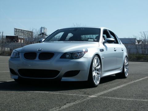 2001 Mercury Grand Marquis - Silver BMW sedan with aftermarket wheels, parked in a lot under a clear sky.