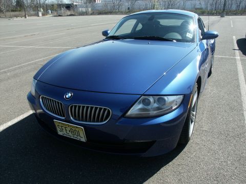 2001 Mercury Grand Marquis - A blue BMW Z4 coupe is parked in an empty lot, showing its front 3/4 view and a New Jersey license plate.