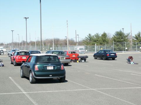 2001 Mercury Grand Marquis - A green Mini Cooper is parked in a lot with other vehicles, possibly at an event.