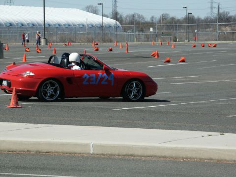 2001 Mercury Grand Marquis - A red convertible sports car navigates a course marked by orange cones on a sunny day.