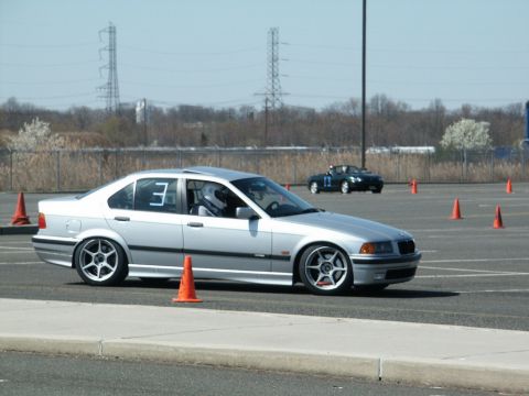 2001 Mercury Grand Marquis - Silver BMW sedan navigates a course marked by orange cones, with another car visible in the distance.