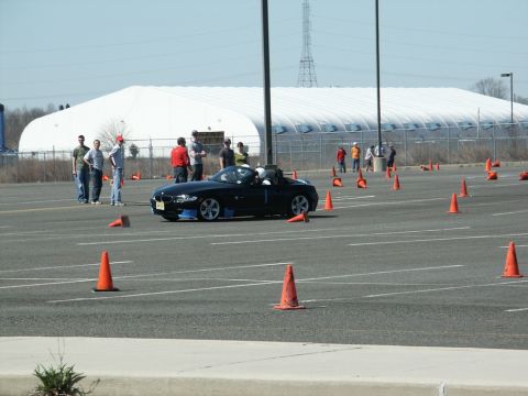 2001 Mercury Grand Marquis - Sports car navigates a course marked by orange cones in a parking lot.