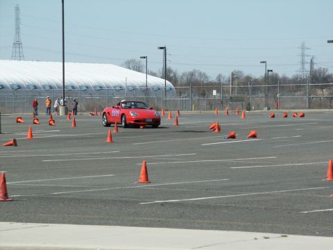 2001 Mercury Grand Marquis - A red convertible is driven through an autocross course marked by orange cones in a large paved area.