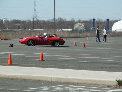 2001 Mercury Grand Marquis - A red convertible sports car navigates a course marked by orange cones on a sunny day.